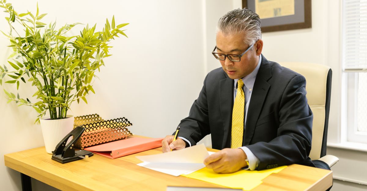 A university administrator working at a desk in a modern office